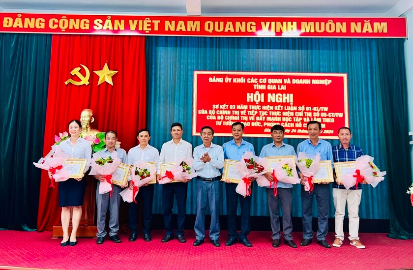 Phó Bí thư Đảng ủy Khối Huỳnh Tấn Đoan (ở giữa) tặng giấy khen các cá nhân có thành tích trong học tập và làm theo Bác. Ảnh: M.N