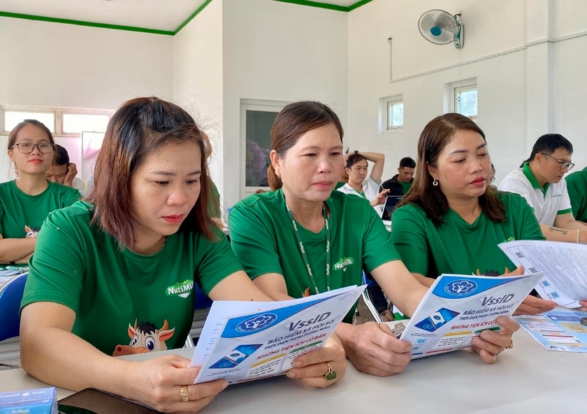 Các đoàn viên, người lao động của Công ty cổ phần Chăn nuôi Bò thịt-Bò sữa Cao Nguyên đọc các thông tin về BHXH, BHYT thông qua các tờ rơi. Ảnh: Hà Duy