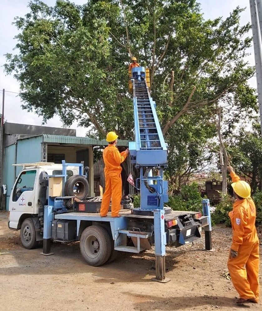 Công nhân Điện lực Chư Sê tiến hành cắt cây xanh gần lưới điện để đảm bảo an toàn. Ảnh: Q.T