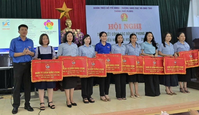 Anh Thái Giang Nam (bìa trái)-Bí thư Thành Đoàn Pleiku trao cờ thi đua cho các đơn vị dẫn đầu cụm thi đua công tác Đội năm học 2023-2024. Ảnh: M.N