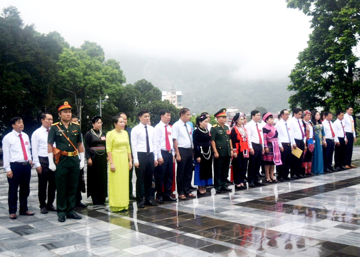 Các đại biểu thực hiện nghi thức dâng hoa, báo công trước tượng đài Bác Hồ trong khuôn viên Tỉnh ủy.