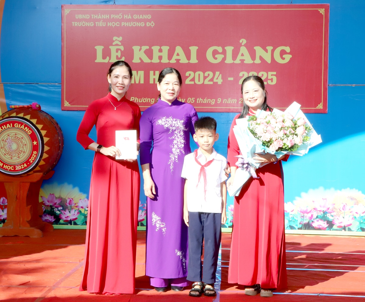 Bí thư Thành ủy Chúng Thị Chiên tặng hoa chúc mừng cô – trò Trường Tiểu học xã Phương Độ nhân ngày khai trường.