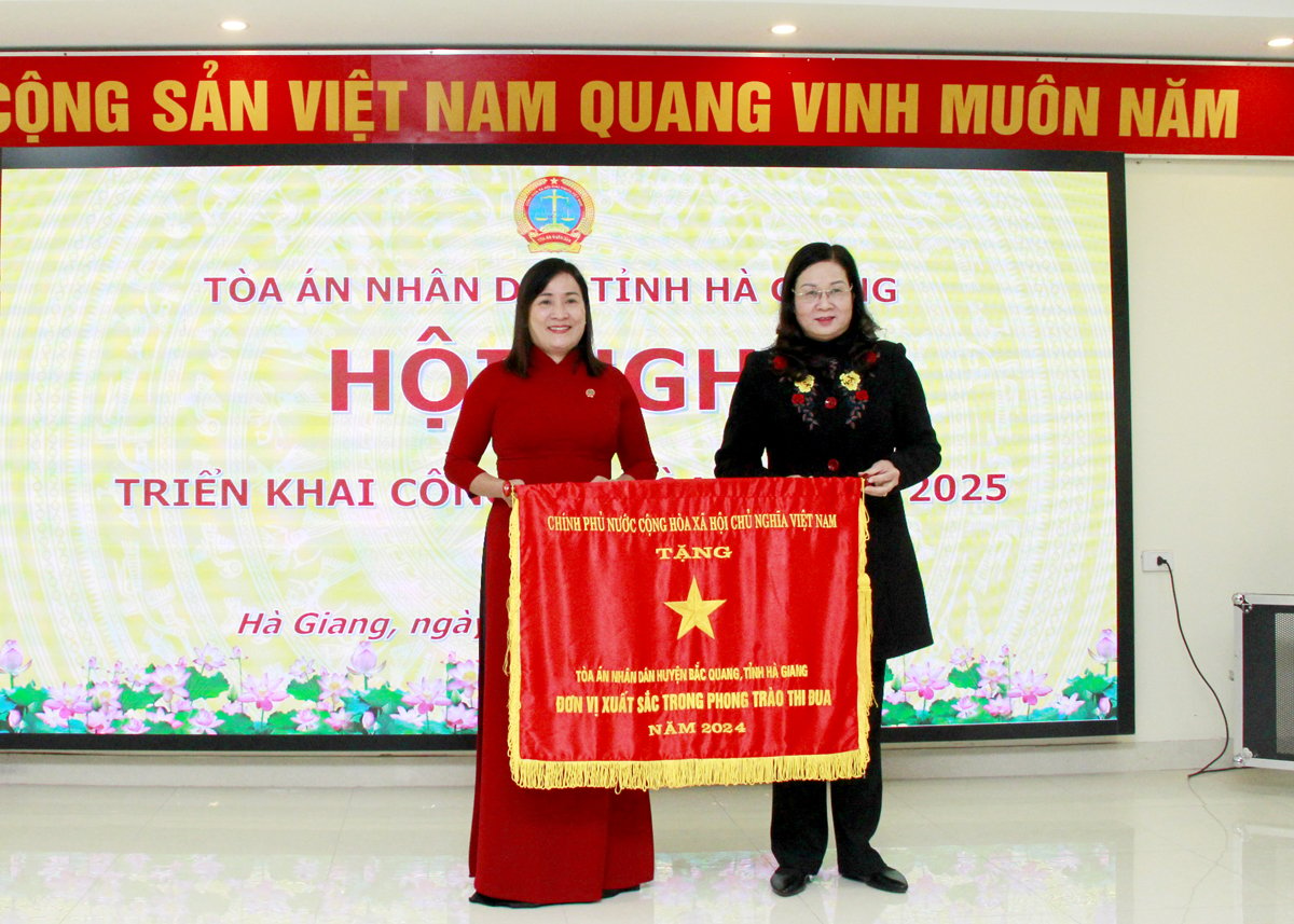 Phó Chủ tịch UBND tỉnh Hà Thị Minh Hạnh trao Cờ thi đua của Chính phủ cho lãnh đạo TAND huyện Bắc Quang.