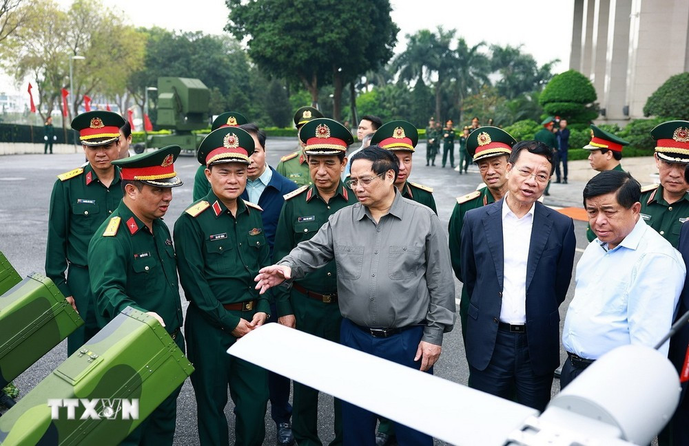 Thủ tướng Phạm Minh Chính trao đổi về sản phẩm công nghệ cao của Tập đoàn Viettel. (Ảnh: Dương Giang/TTXVN)