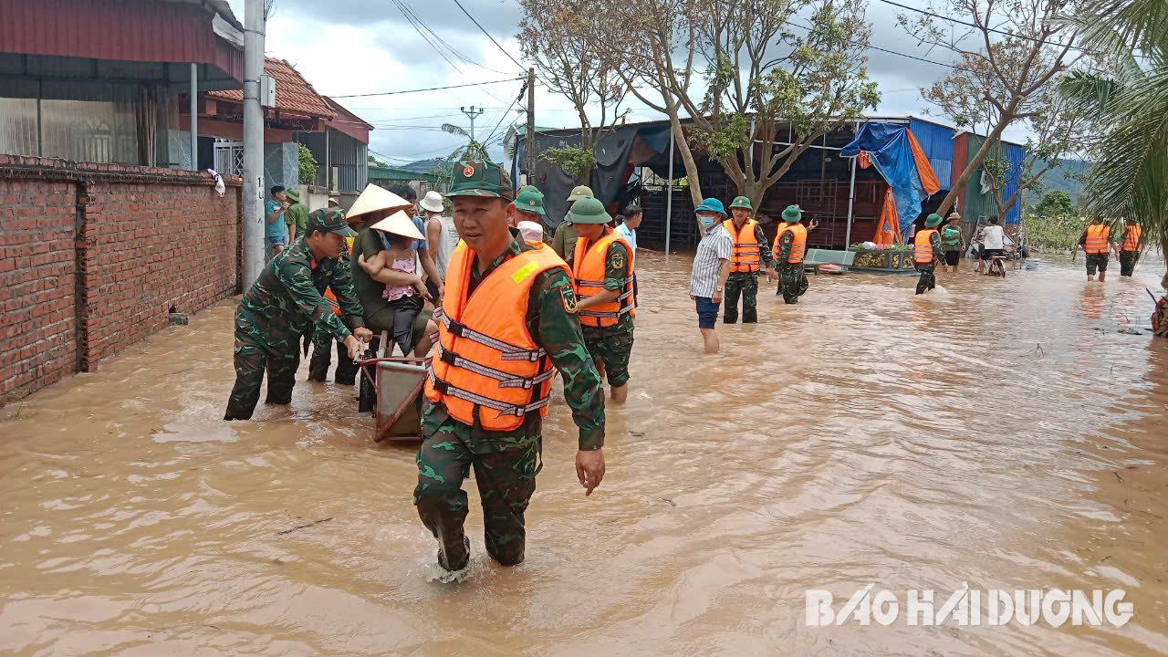 Cán bộ, chiến sĩ của Ban Chỉ huy quân sự huyện Kim Thành hỗ trợ nhiều gia đình di chuyển từ ngoài bãi đê về nơi an toàn. Ảnh: Nguyễn Thảo