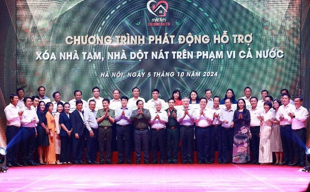 Thủ tướng Phạm Minh Chính với các đại diện các tổ chức, doanh nghiệp hỗ trợ kinh phí xóa nhà tạm, nhà dột nát. (Ảnh: Dương Giang/TTXVN)