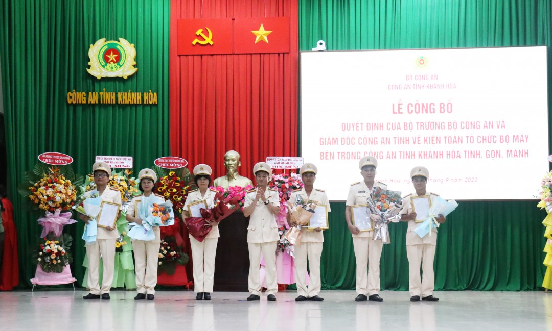 Đại tá Nguyễn Thế Hùng, Giám đốc Công an tỉnh trao quyết định và tặng hoa chúc mừng lãnh đạo phòng nghiệp vụ sau khi sáp nhập