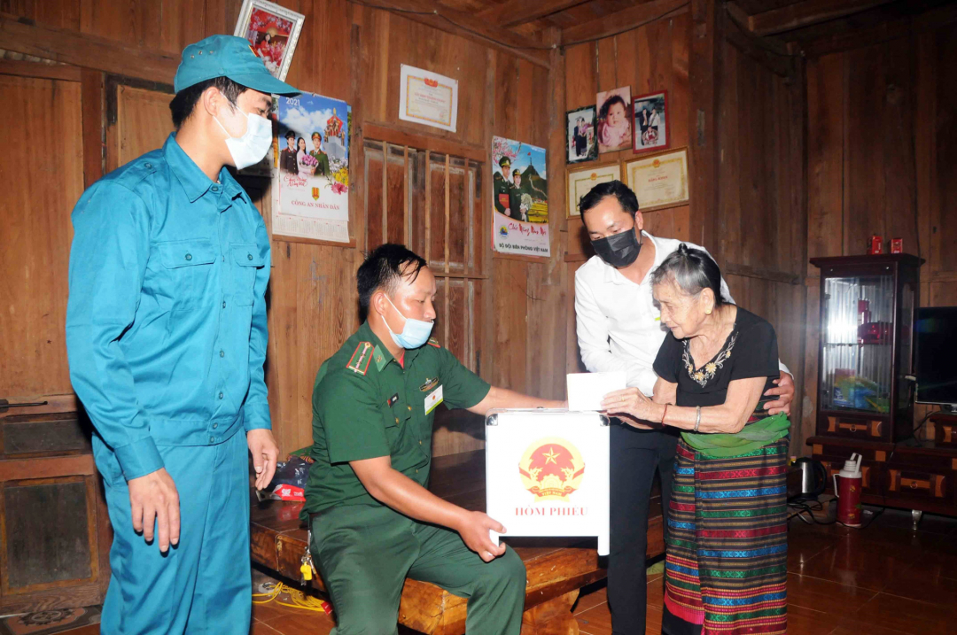 Để bảo đảm quyền lợi của cử tri, thành viên Tổ bầu cử số 05, bản Mường Lạn, xã Mường Lạn, huyện Sốp Cộp, tỉnh Sơn La mang hòm phiếu đến tận nhà để cử tri Lò Thị Pỉ (96 tuổi) được tận tay bỏ phiếu bầu cử đại biểu Quốc hội khóa XV và hội đồng nhân dân các cấp nhiệm kỳ 2021 - 2026._Ảnh: TTXVN

