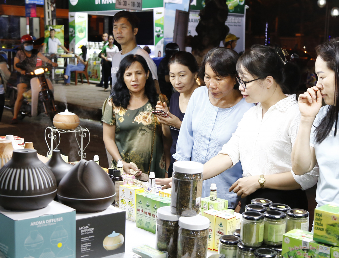 Người tiêu dùng tham quan một gian hàng tinh dầu, thảo mộc tại phiên chợ ở Khánh Hòa. 