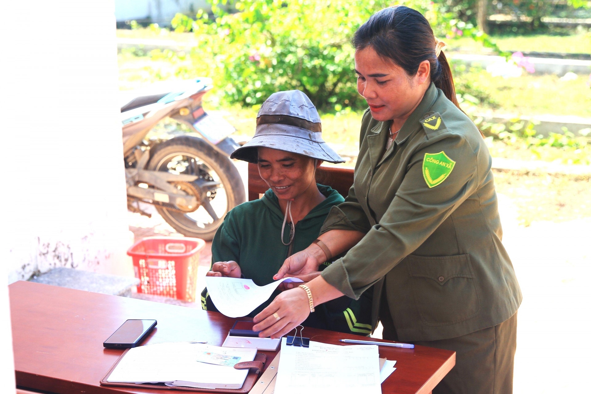 Chị Tro Thị Khoanh hỗ trợ người dân thực hiện các thủ tục hành chính.