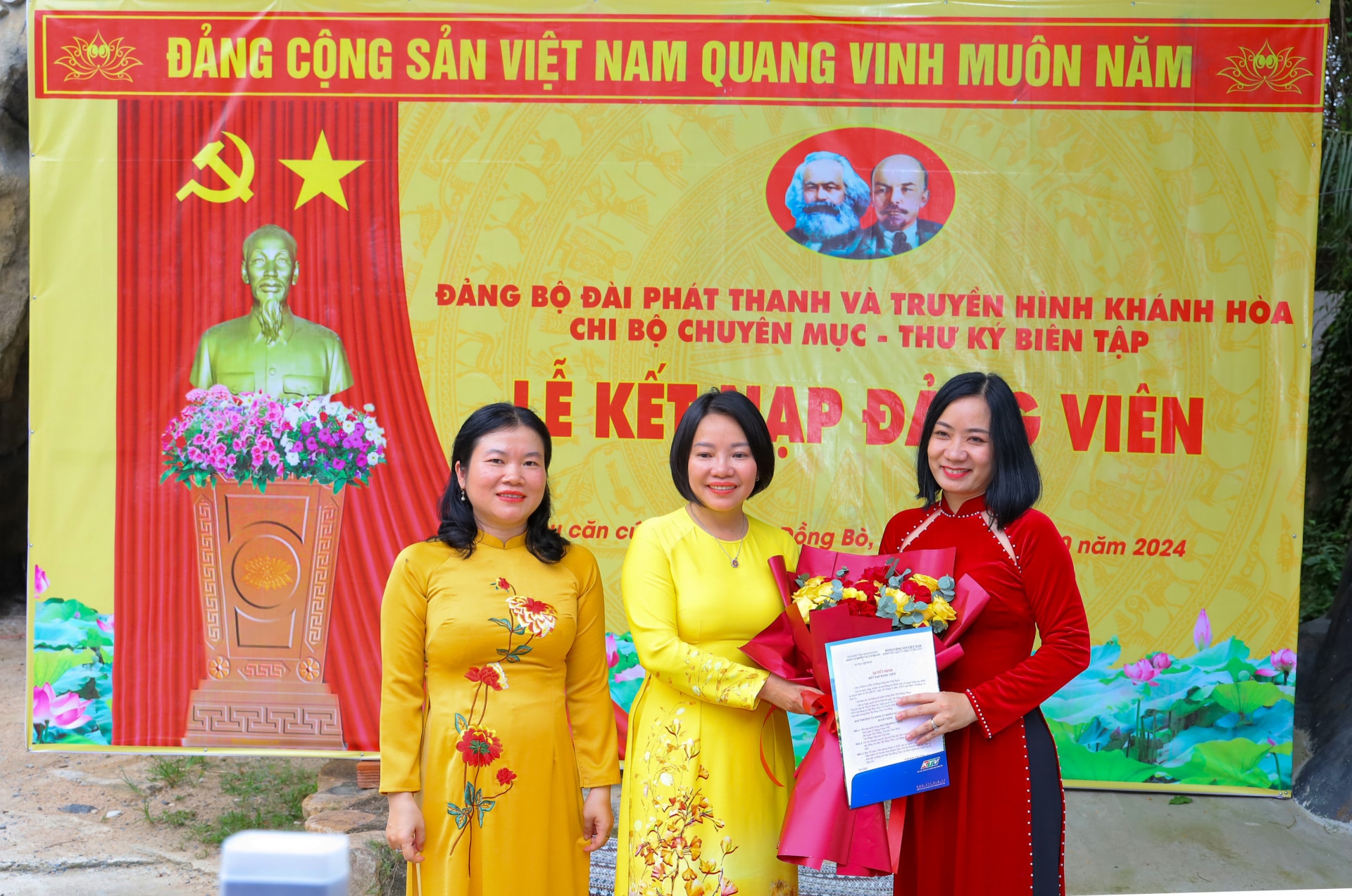 Bà Thái Thị Lệ Hằng cùng Bí thư Chi bộ Chuyên mục - Thư ký biên tập trao quyết định và tặng hoa chúc mừng đảng viên mới Mai Thị Hồng Thúy.