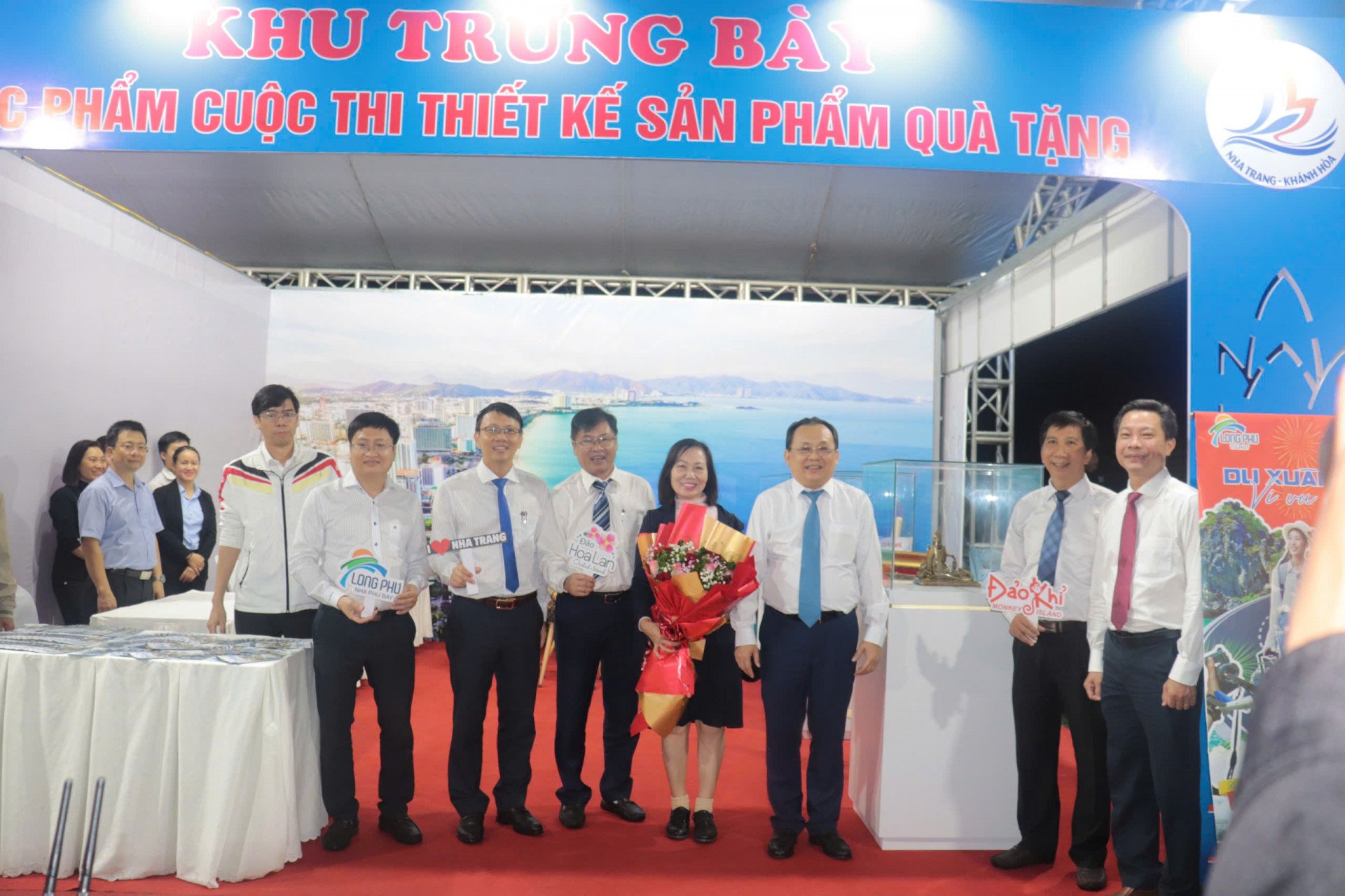 Các đại biểu chụp hình lưu niệm tại gian hàng trưng bày các tác phẩm cuộc thi thiết kế sản phẩm quà tặng