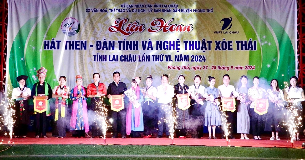 Đại diện Ban Tổ Chức Liên hoan trao hoa và cờ lưu niệm cho các đoàn về tham dự.