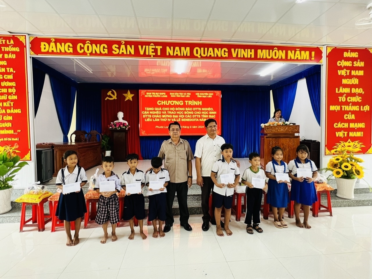 Ông Hứa Ngọc Triệu, Phó Trưởng Ban Dân tộc và Tôn giáo (áo nâu) trao tặng quà, học bổng tại huyện Phước Long