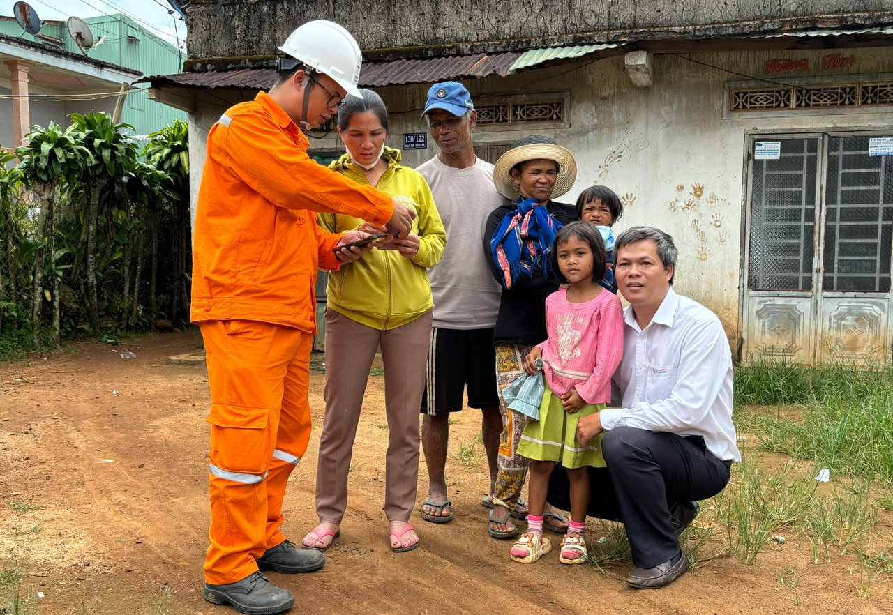 Nhân viên ngành điện hướng dẫn khách hàng thôn BĐạ, thị trấn Lộc Thắng, Bảo Lâm thanh toán tiền điện không dùng tiền mặt