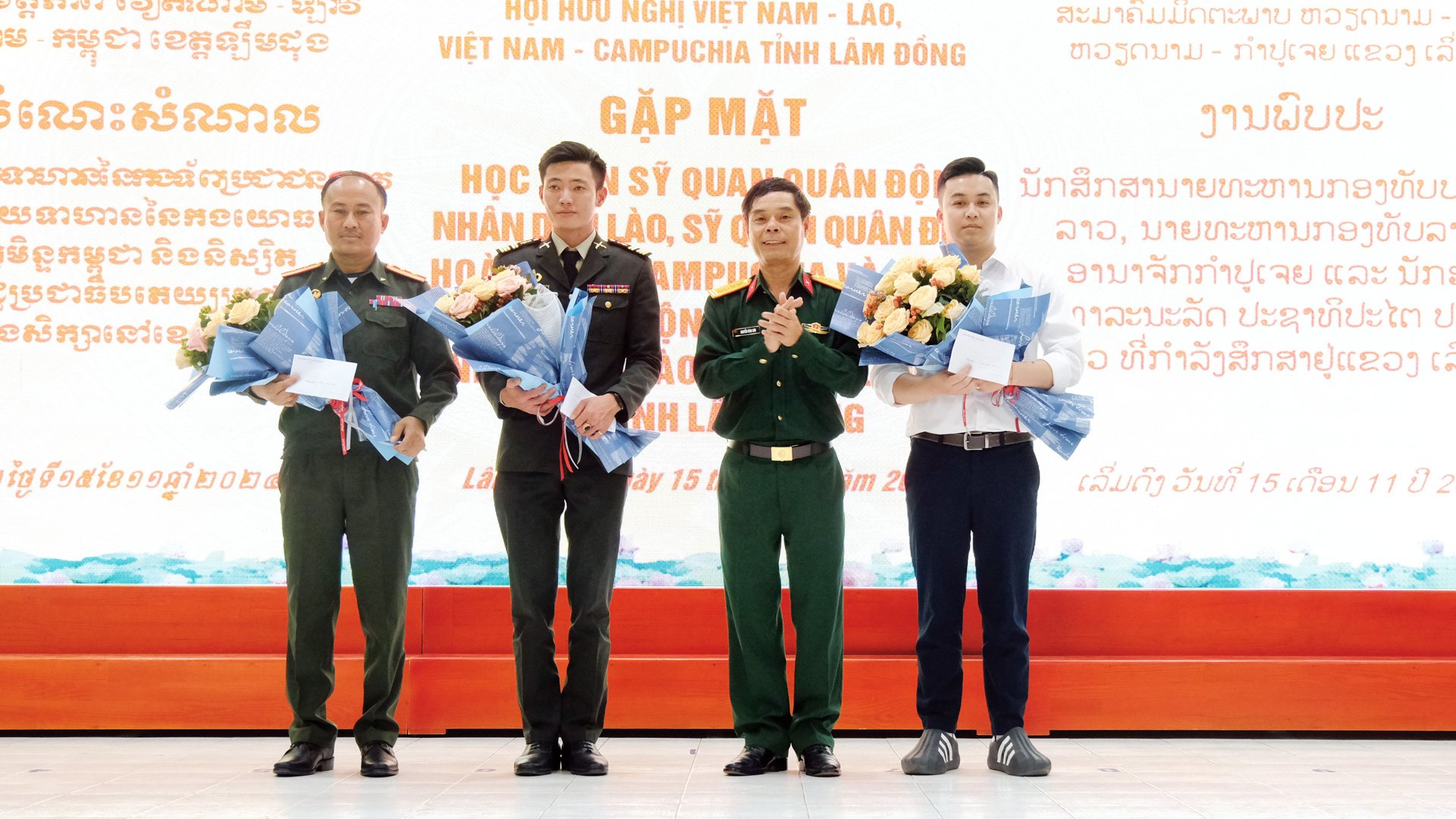 Đại tá Nguyễn Bình Sơn - Ủy viên Ban Thường vụ Tỉnh ủy, Chỉ huy trưởng Bộ CHQS tỉnh tặng hoa và quà 
đại diện sĩ quan Quân đội Nhân dân Lào, sĩ quan Quân đội Hoàng gia Campuchia và sinh viên Lào