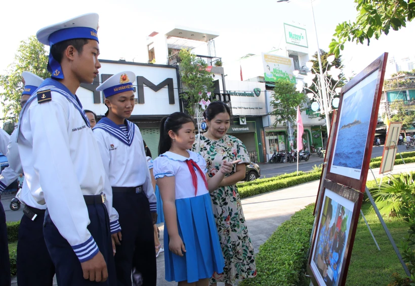 Các chiến sỹ và học sinh xem ảnh tại triển lãm ảnh “Hoàng Sa - Trường Sa trong lòng Quảng Ngãi”. (Ảnh: Đinh Hương/TTXVN)