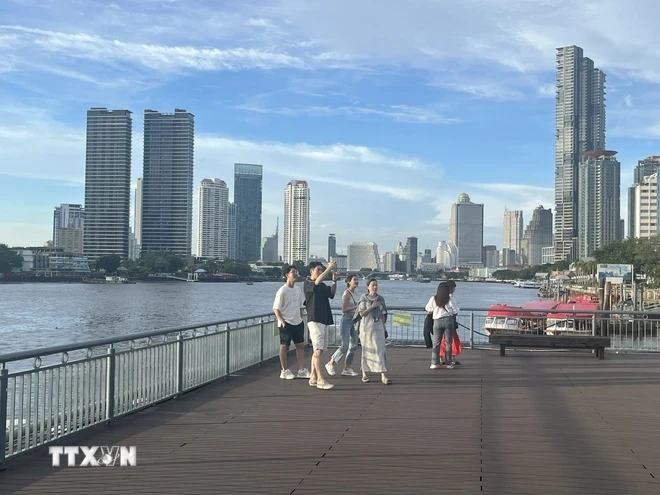 Khách du lịch chụp hình bên bờ sông Chao Phraya, Bangkok, Thái Lan. (Ảnh: Huy Tiến/TTXVN)