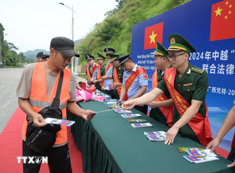 Cán bộ Đồn Biên phòng Tân Thanh, tỉnh Lạng Sơn, tuyên truyền, phát tờ rơi pháp luật biên giới tại cửa khẩu. (Ảnh: Quang Duy/TTXVN)