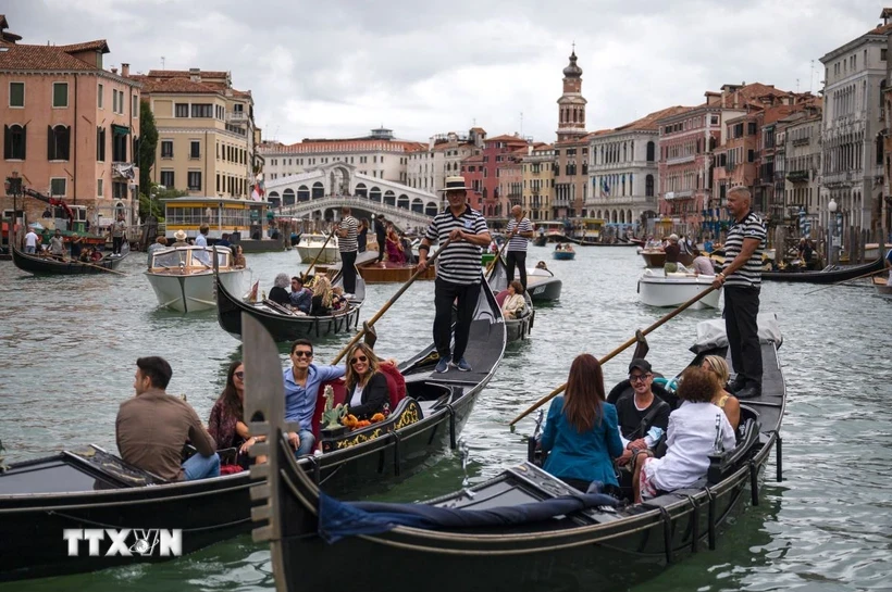 Du khách đi thuyền gondola tại Venice, Italy. (Ảnh: AFP/TTXVN)