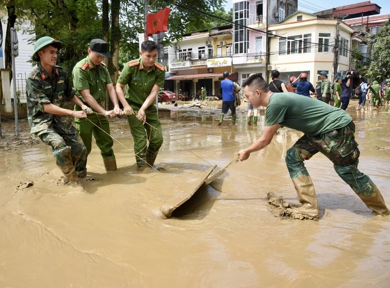 Các lực lượng quân đội và công an giúp nhân dân dọn dẹp vệ sinh môi trường sau bão lũ tại thành phố Yên Bái (Ảnh: Trần Hải).