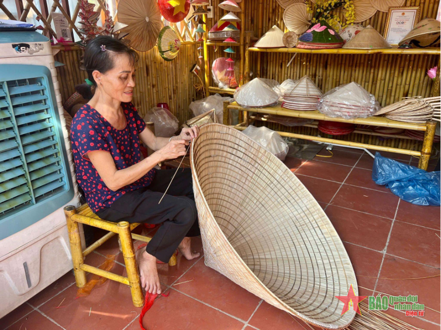 Cô Oanh, nghệ nhân làm nón tại gian trưng bày của bà Tạ Thu Hương. 