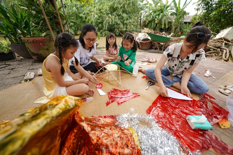 &quot;Vườn nhà chị Lan có nhiều tre. Từ mấy ngày trước, nghe chúng tôi nói có ý muốn làm lồng đèn cho mấy cháu đón trung thu nên anh Tuấn chồng chị Lan đi chẻ tre rồi vót để chị em bày cho mấy đứa nhỏ làm lồng đèn&quot;, chị Kim Thoa (áo sơ mi) kể. ảnh 2