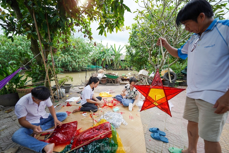 Hình ảnh những chiếc đèn ông sao đã in sâu trong ký ức mỗi người, nó gọi về ký ức tuổi thơ với niềm háo hức có được chiếc đèn để trông trăng. Trung thu xưa, mỗi dịp Rằm tháng tám, các ông bố bà mẹ lại rục rịch vót tre, mua nến làm cho mấy đứa nhỏ chiếc đèn ông sao đón Trung thu. Anh Quốc Tuấn (đứng) hỗ trợ đắc lực cho nhóm phụ huynh thực hiện những chiếc lồng đèn. ảnh 14