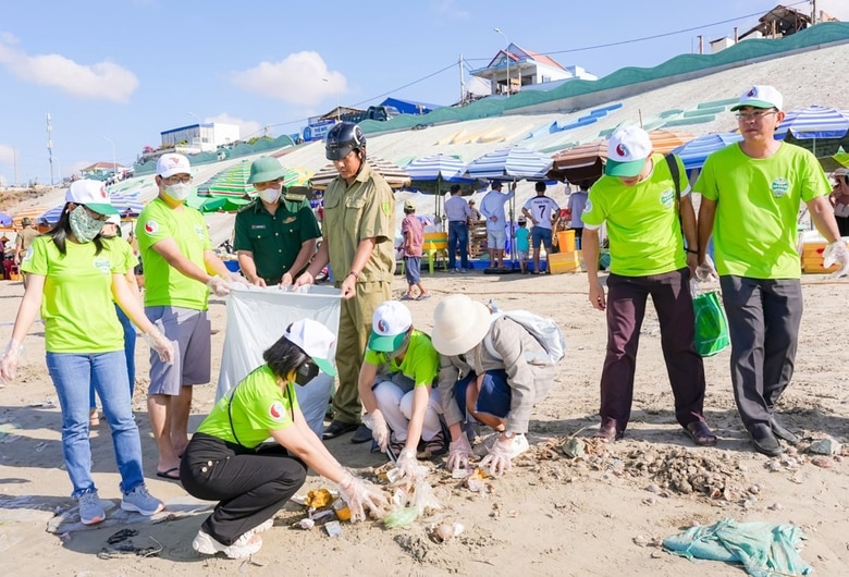 Khách du lịch tham gia hoạt động bảo vệ môi trường tại bãi biển Mũi Né (tỉnh Bình Thuận).