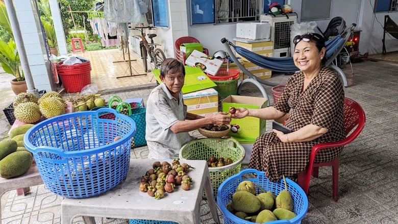 Du khách đến từ TP.Dĩ An thích thú khi mua và thưởng thức trái cây tại Vườn cây 99.