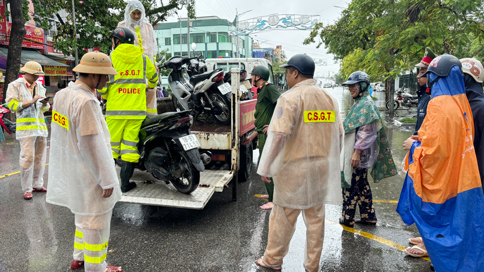 Lực lượng Cảnh sát Giao thông (Công an tỉnh) hỗ trợ người dân di chuyển phương tiện qua điểm ngập lụt chân cầu Đò Quan (thành phố Nam Định) do ảnh hưởng của hoàn lưu bão số 3 (bão Yagi).