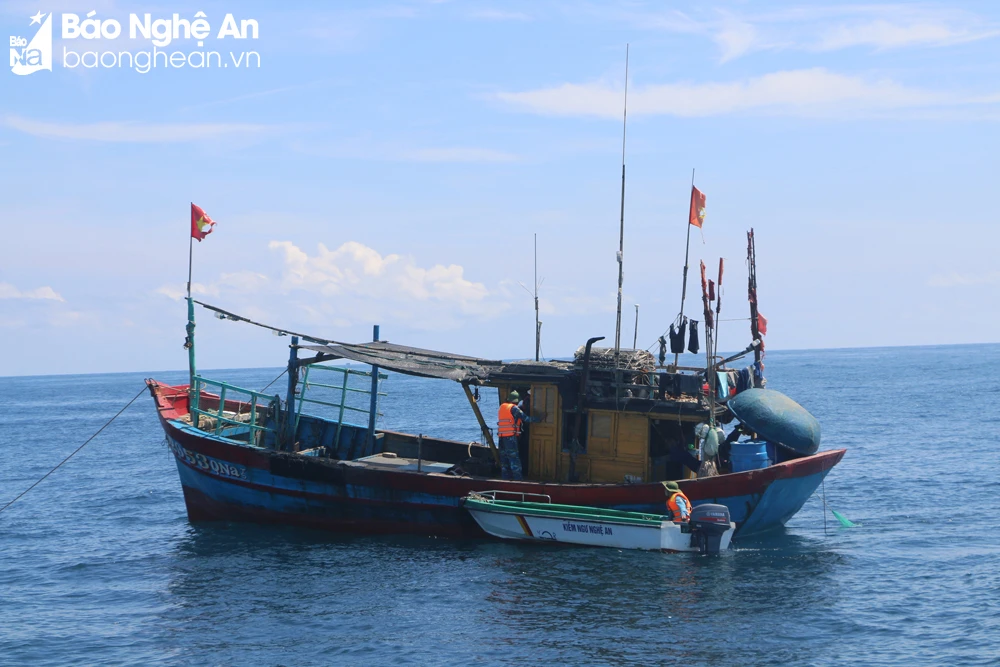 bna_Nghe An Fisheries Surveillance Force nähert sich, um die Fischereiabläufe eines Fischerboots im Offshore-Gebiet in der Nähe von Mat Island, Nghe An, zu überprüfen.JPG