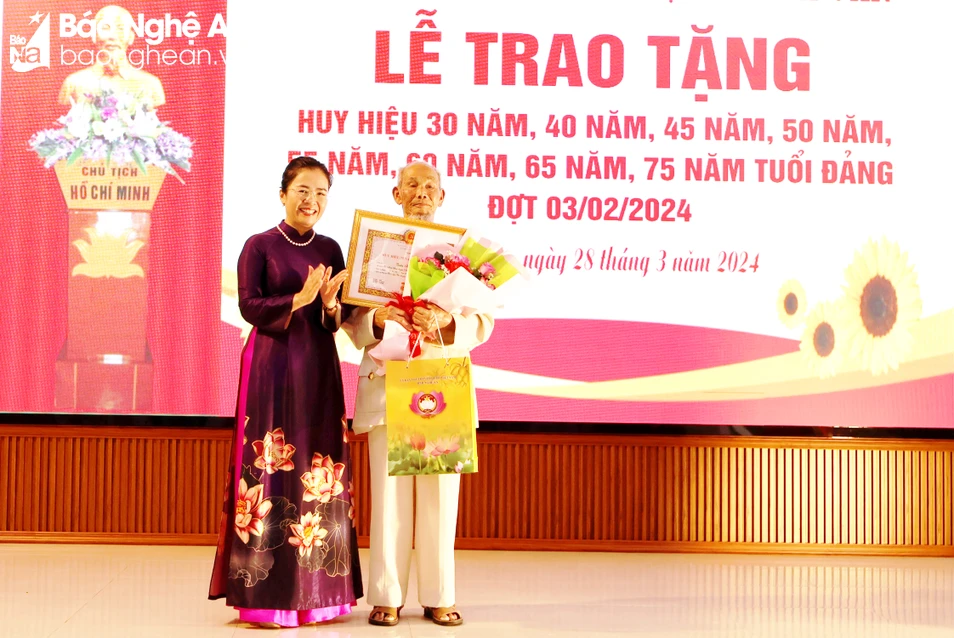 bna-Chủ tịch Ủy ban MTTQ tỉnh Võ Thị Minh Sinh trao Huy hiệu 75 năm tuổi Đảng và tặng hoa chúc mừng đảng viên Trần Hữu Phổ.JPG