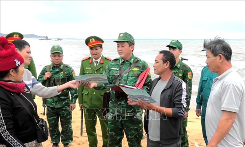 Cán bộ, chiến sỹ Đồn Biên phòng Lý Hòa và các đơn vị trên địa bàn xã Đức Trạch, huyện Bố Trạch, tỉnh Quảng Bình cấp phát tờ rơi, tuyên truyền bà con ngư dân khai thác hải sản đúng quy định pháp luật. Ảnh: TTXVN phát