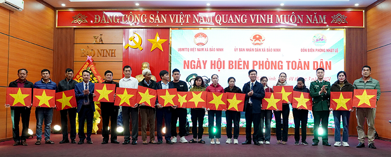 Đại diện lãnh đạo Ủy ban MTTQVN tỉnh, TP. Đồng Hới và Đồn Biên phòng Nhật Lệ tặng cờ Tổ quốc cho các ngư dân.