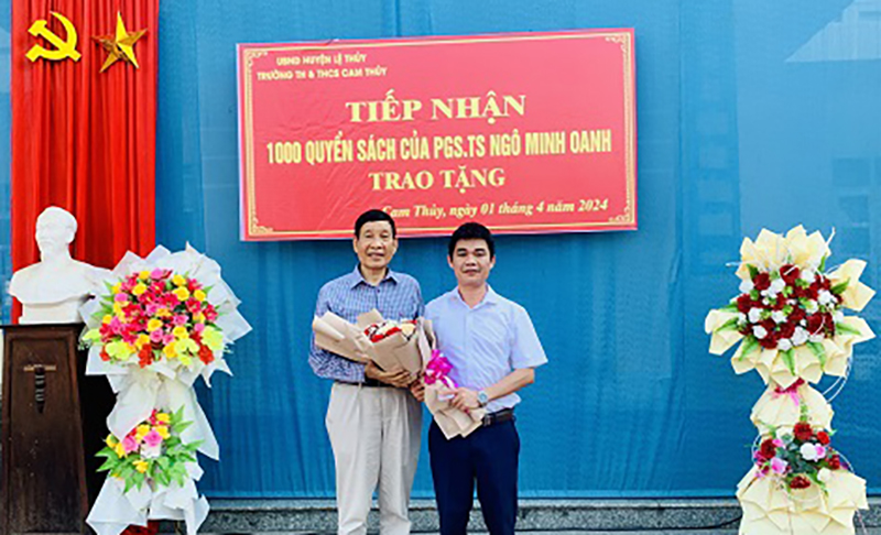 PGS.TS. Ngô Minh Oanh (bìa trái) tại lễ trao tặng sách ở xã Cam Thủy (Lệ Thủy).