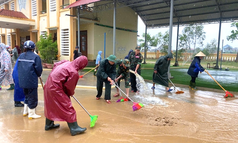 Bộ đội, dân quân huyện Quảng Ninh tham gia khắc phục thiệt hại tại các trường học. 