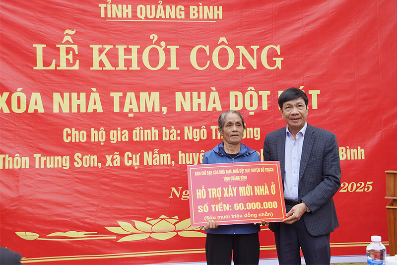 Đồng chí Phó Chủ tịch Thường trực HĐND tỉnh Nguyễn Công Huấn trao biển hỗ trợ kinh phí xây nhà cho gia đình bà Ngô Thị Hồng.