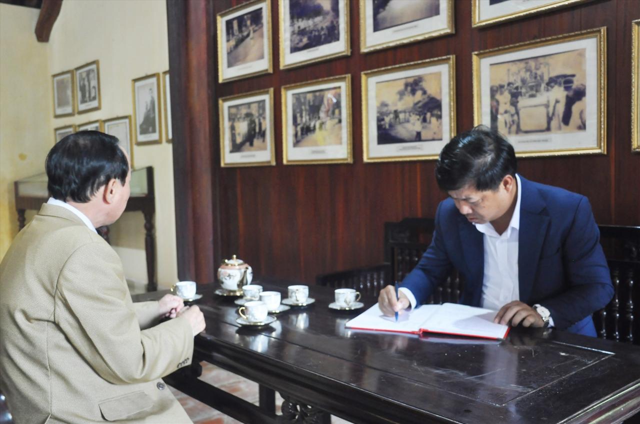 Le secrétaire provincial du Parti, Luong Nguyen Minh Triet, écrit dans le livre d'or de la Maison commémorative Phan Chau Trinh. Photo : N.D.