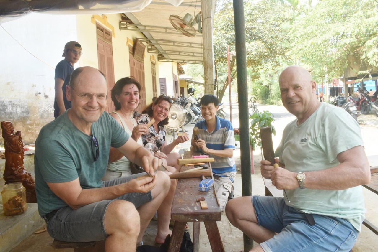 Les touristes occidentaux semblent très enthousiastes lorsqu'ils visitent le village de menuiserie de Kim Bong. Photo : N.Q