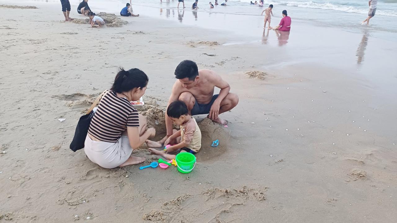 La plupart des familles emmènent leurs enfants à la plage pour nager et s'amuser après les heures de travail et d'école. Photo : Q.H