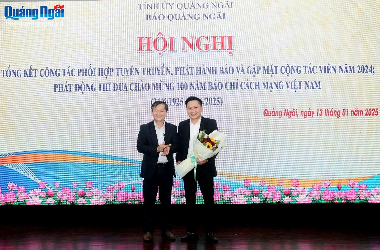 Tổng Biên tập Báo Quảng Ngãi tặng hoa cho đại diện lãnh đạo BIDV Chi nhánh Dung Quất - đơn vị tài trợ cho Cuộc thi viết Mái ấm cho đồng bào tôi.