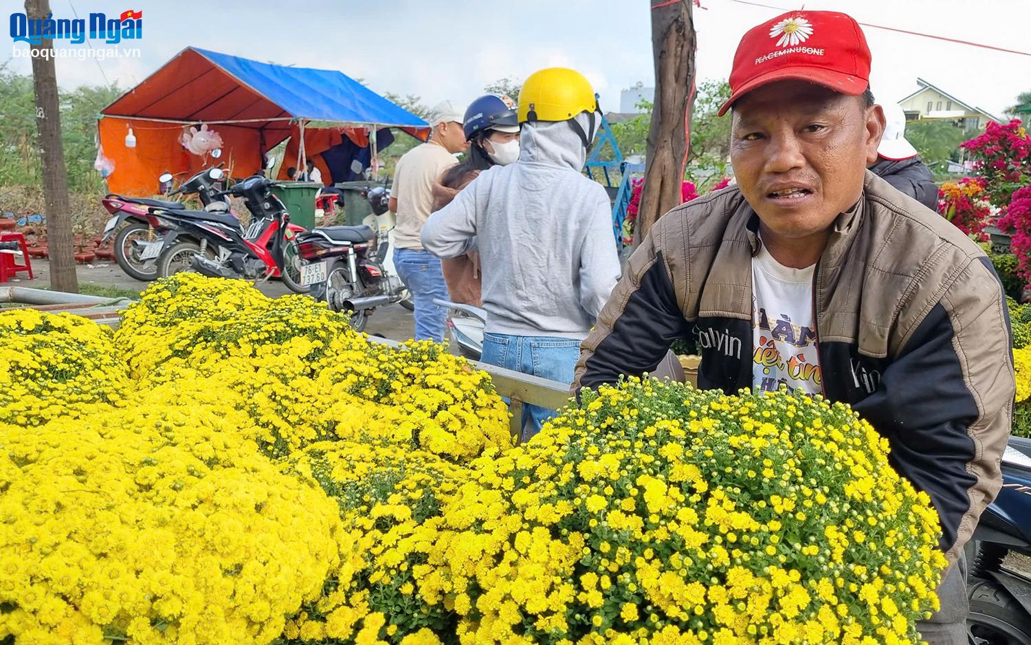 Những tiểu thương chờ đợi khách mua hoa, thỉnh thoảng có vài người khách đi qua, ghé lại hỏi giá rồi tiếp tục đi.