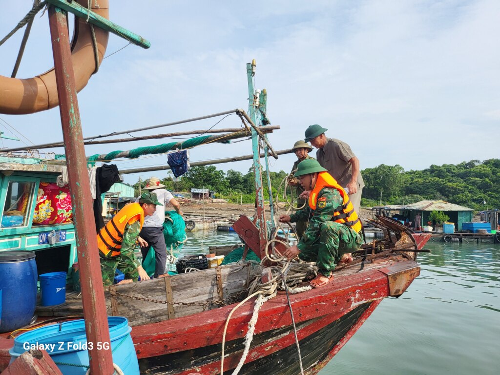 Cán bộn chiến sĩ Đồn BPCK cảng Vạn Gia (BĐBP tỉnh) giúp dân gia cố lồng bè, nuôi thủy sản.