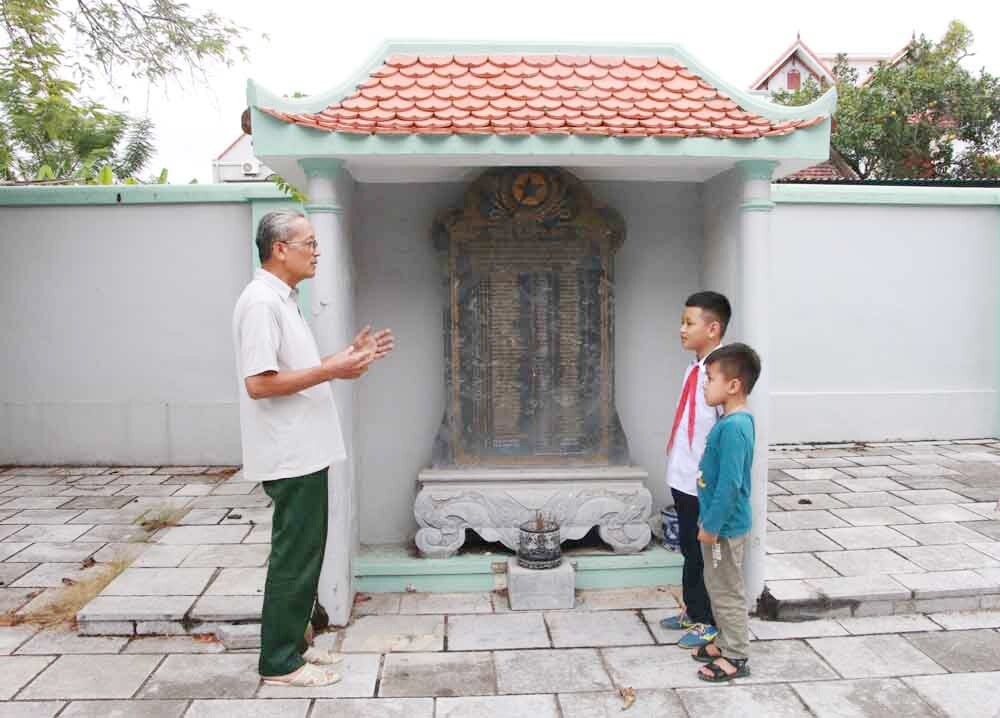 Ông Ngô Minh Tâm, Hội đồng gia tộc họ Ngô Tiên Công phường Phong Cốc giới thiệu lịch sử dòng họ cho các cháu. (Ảnh Nguyễn Dung)