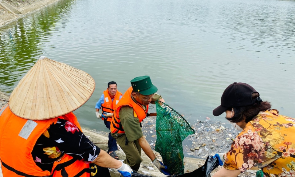 Cán bộ, hội viên Hội phụ nữ khu phố 1 (phường Hùng Thắng) tham gia vớt rác thải tại hồ Hùng Thắng.  Ảnh Hoàng Nga