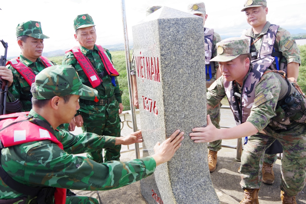 Hai đội trưởng tuần tra song phương kiểm tra tình trạng thân cột mốc biên giới Việt Nam - Trung Quốc trên biển.