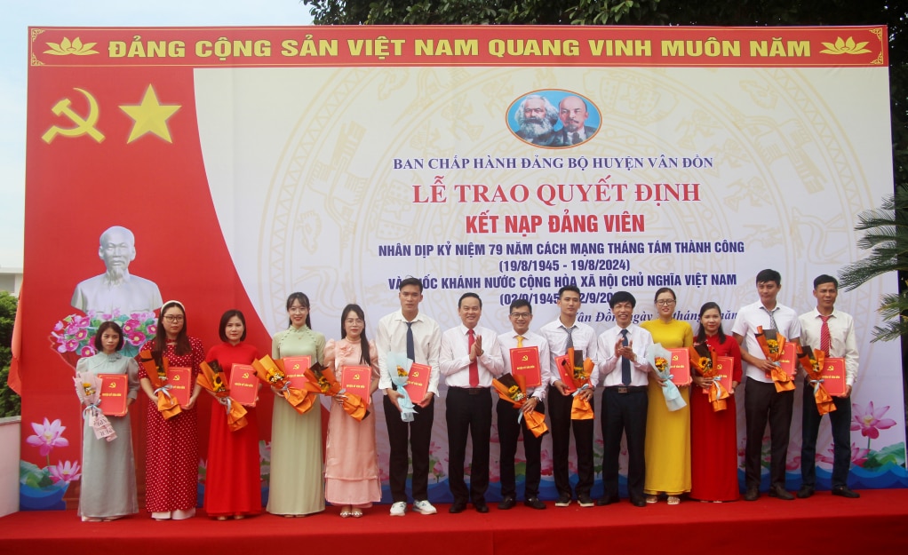 Comrade Truong Manh Hung, Secretary of the District Party Committee and Comrade To Van Hai, Standing Deputy Secretary of the District Party Committee, Chairman of the People's Council of Van Don district, presented the Decision and flowers to congratulate the new party members. Photo: Manh Truong