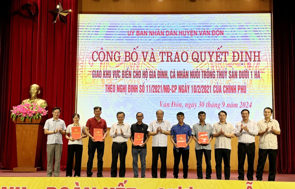 Lãnh đạo tỉnh, huyện Vân Đồn và các sở, ngành liên quan chúc mừng các hộ dân đầu tiên được trao quyết định giao khu vực biển để nuôi trồng thủy sản. Ảnh: Mạnh Trường