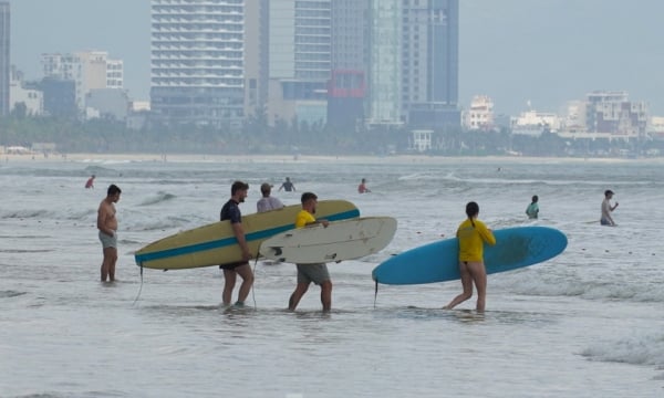 Los turistas acuden en masa a la playa de Da Nang para "montar las olas" en la fría temporada de lluvias